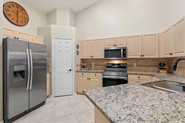 kitchen with light brown cabinets, appliances with stainless steel finishes, and a sink