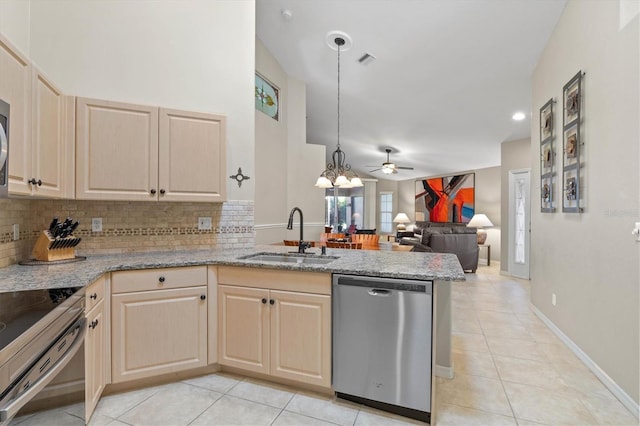 kitchen with a peninsula, a sink, visible vents, appliances with stainless steel finishes, and tasteful backsplash