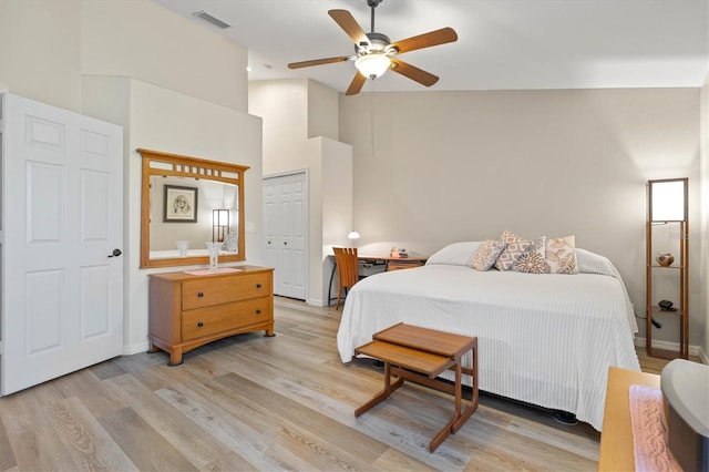 bedroom with light wood-type flooring, a closet, visible vents, and ceiling fan