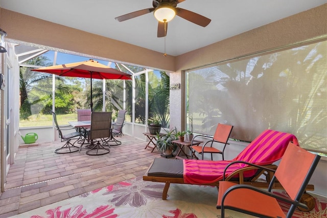 sunroom / solarium featuring plenty of natural light and a ceiling fan