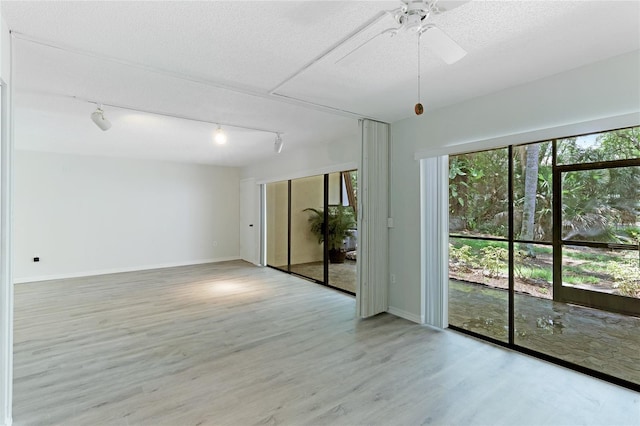 empty room featuring hardwood / wood-style flooring, ceiling fan, and a textured ceiling