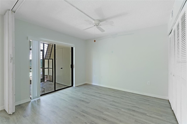 unfurnished bedroom featuring a textured ceiling, light wood-type flooring, and ceiling fan