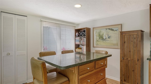 dining space featuring a textured ceiling and light wood-type flooring