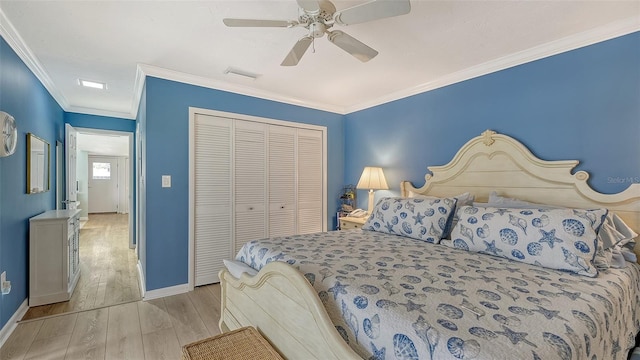 bedroom featuring crown molding, light hardwood / wood-style flooring, a closet, and ceiling fan