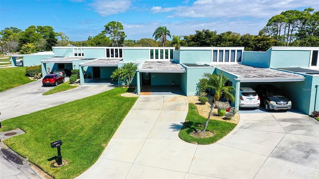 view of front of home with a carport and a front lawn