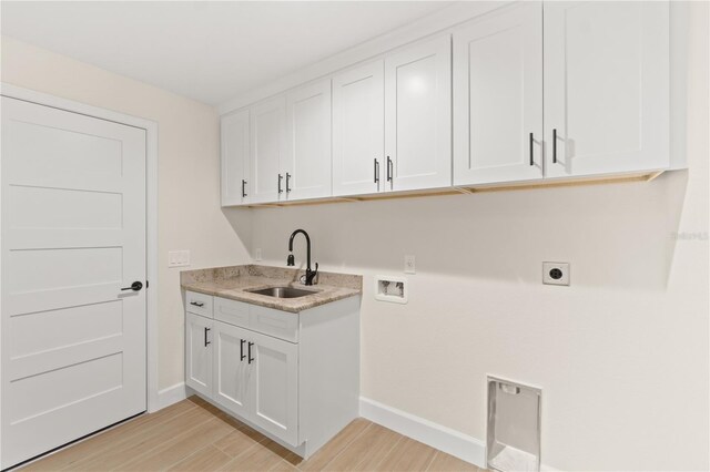 washroom with light wood-style floors, cabinet space, electric dryer hookup, washer hookup, and a sink