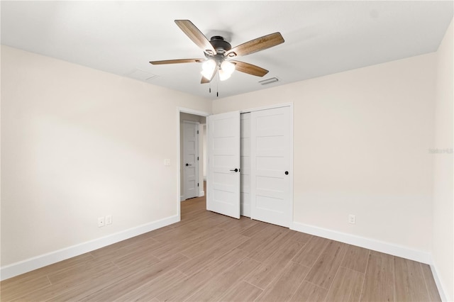 unfurnished bedroom with baseboards, a closet, visible vents, and light wood finished floors