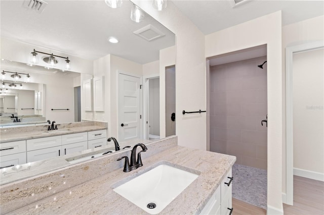 bathroom featuring hardwood / wood-style floors and dual vanity