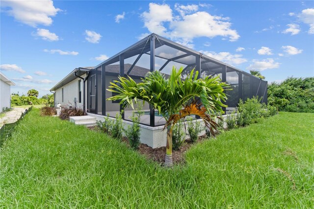 view of home's exterior with a lanai and a yard