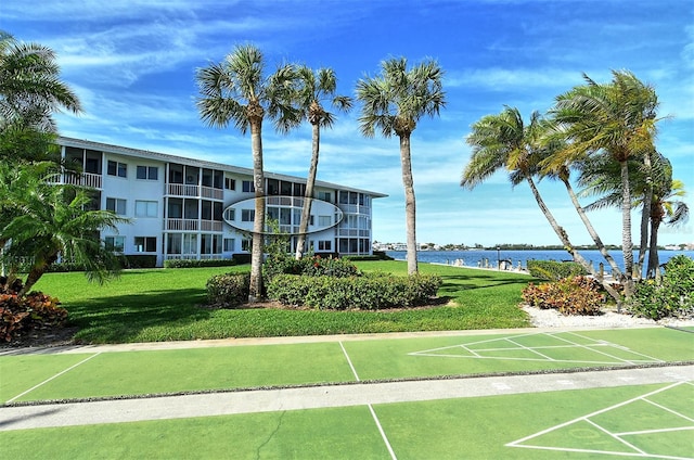 view of home's community featuring a water view and a lawn