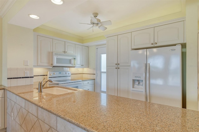 kitchen with white appliances, ceiling fan, sink, ornamental molding, and light stone countertops