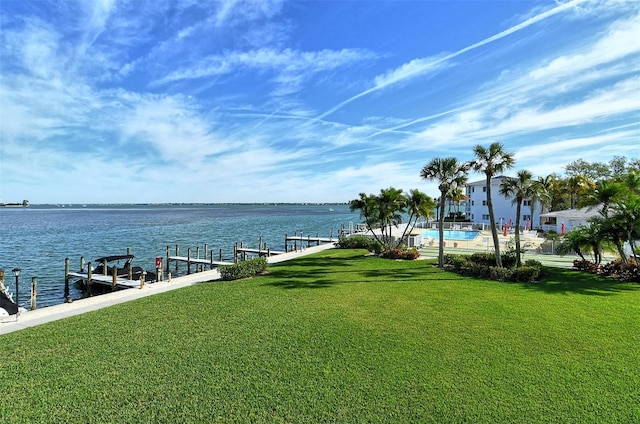 dock area with a lawn and a water view