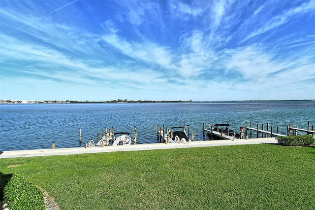 dock area with a yard and a water view