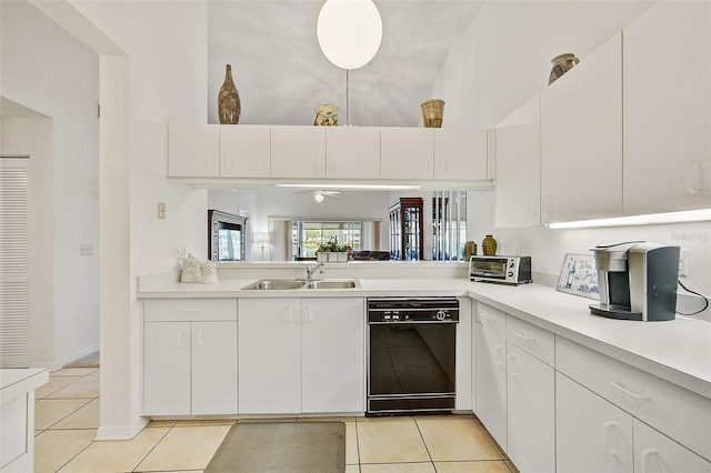 kitchen with dishwasher, light tile patterned floors, white cabinetry, ceiling fan, and sink