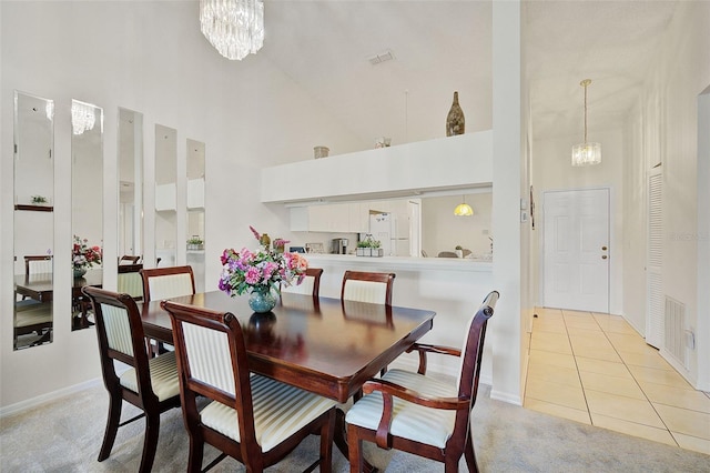 dining space featuring a high ceiling, an inviting chandelier, and light tile patterned flooring