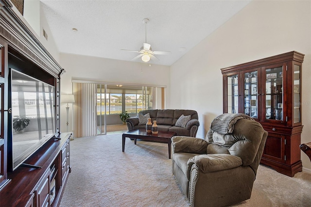 living room with ceiling fan, light colored carpet, and lofted ceiling