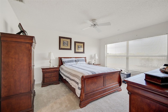 carpeted bedroom with a textured ceiling and ceiling fan