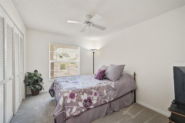 carpeted bedroom with ceiling fan, a closet, and a textured ceiling