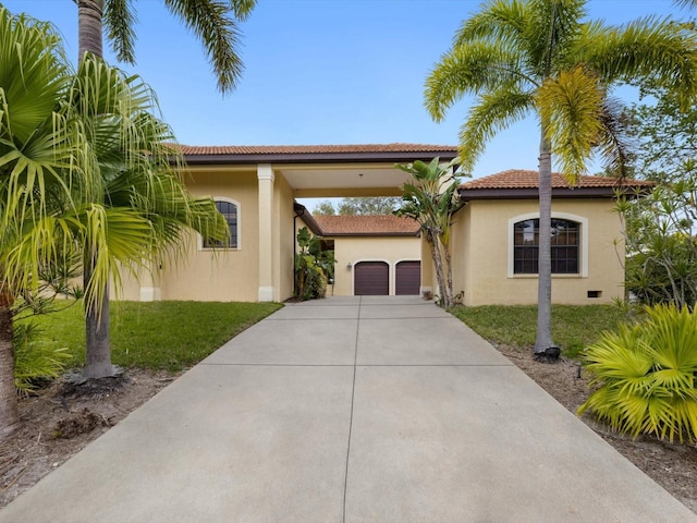 mediterranean / spanish house with a front lawn and a garage