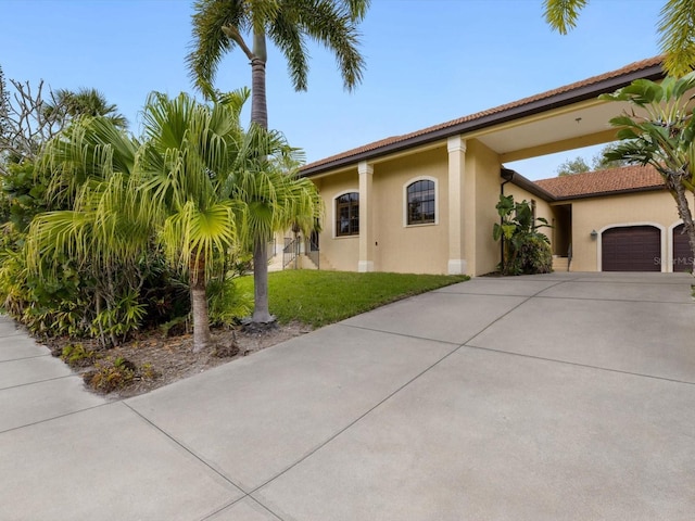 mediterranean / spanish-style house featuring a front lawn and a garage