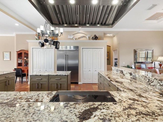 kitchen featuring light tile flooring, built in refrigerator, a notable chandelier, light stone counters, and crown molding