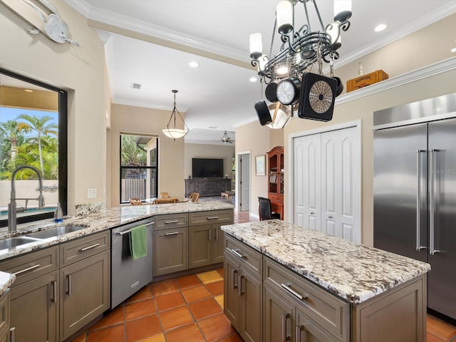 kitchen featuring stainless steel appliances, a notable chandelier, light tile floors, sink, and light stone counters