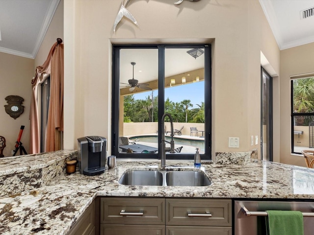 kitchen with ornamental molding, stainless steel dishwasher, sink, and light stone counters