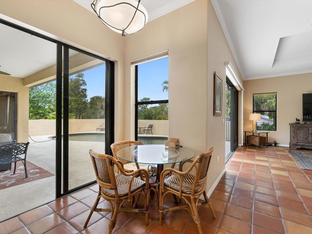 tiled dining room with ornamental molding and a wealth of natural light