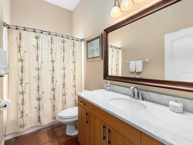 bathroom with tile flooring, large vanity, and toilet