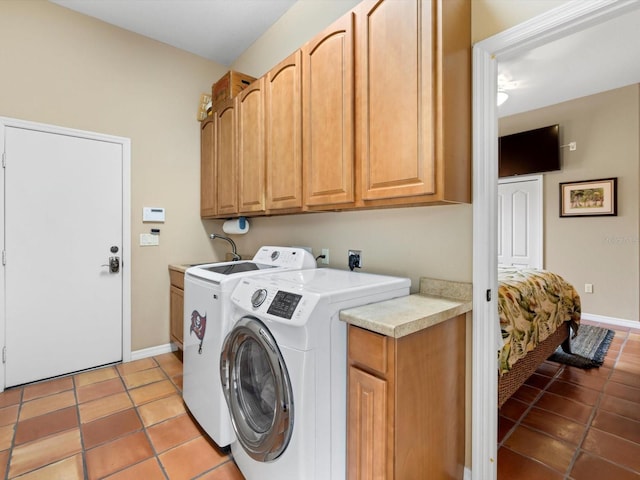 clothes washing area with electric dryer hookup, independent washer and dryer, cabinets, and light tile flooring