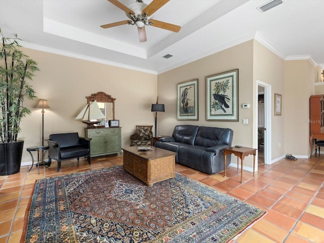 tiled living room featuring ornamental molding, ceiling fan, and a tray ceiling