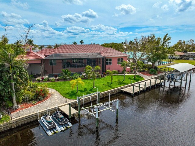 dock area with a water view, a lanai, and a lawn