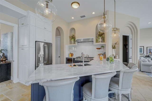 kitchen with white cabinetry, sink, light tile floors, light stone counters, and stainless steel refrigerator with ice dispenser