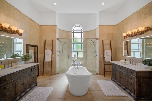 bathroom featuring tile walls, tile flooring, dual vanity, and a wealth of natural light