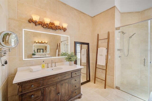 bathroom with tile walls, tile floors, a shower with shower door, and vanity