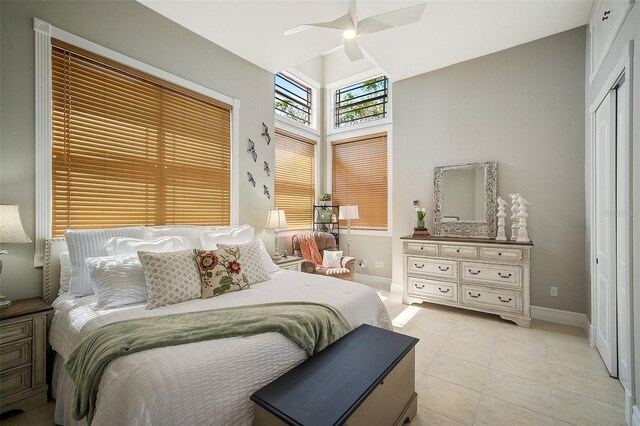 bedroom featuring light tile floors, a closet, and ceiling fan