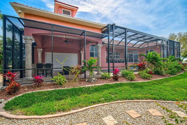 rear view of property with glass enclosure and ceiling fan