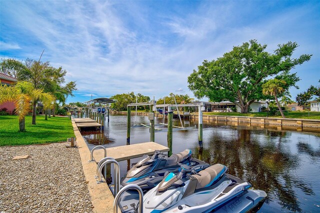 view of dock featuring a yard and a water view