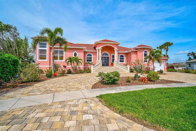 mediterranean / spanish home featuring a front lawn