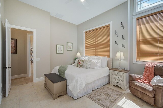 bedroom featuring light tile floors, multiple windows, and ceiling fan