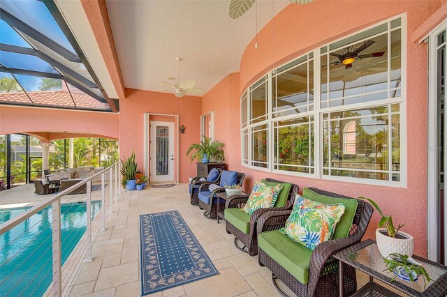 view of pool with a patio area, an outdoor hangout area, glass enclosure, and ceiling fan