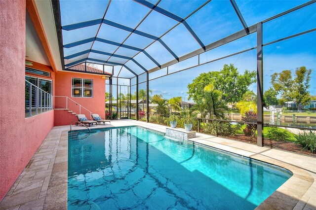 view of pool featuring glass enclosure and a patio area