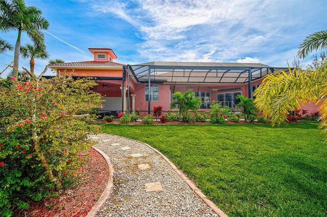 back of property with a yard and a lanai