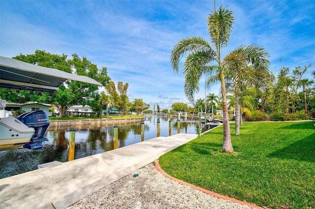 dock area with a lawn and a water view