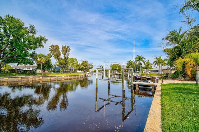 view of dock featuring a water view and a lawn