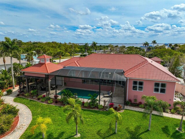 exterior space with a swimming pool, a water view, a front yard, and a lanai