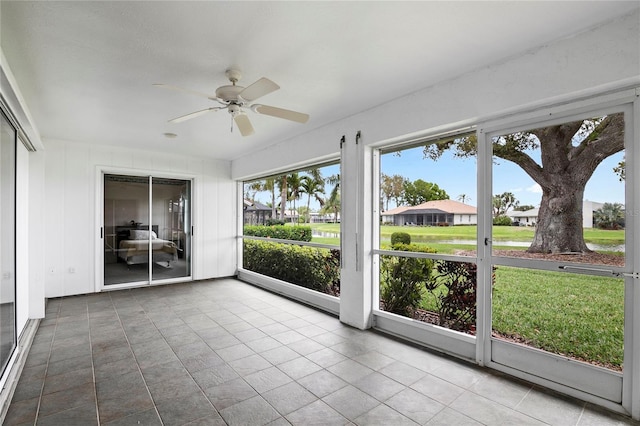 unfurnished sunroom with ceiling fan