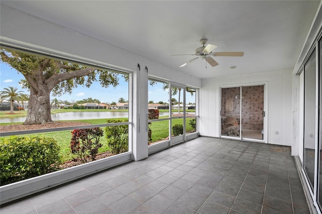 unfurnished sunroom featuring a water view and ceiling fan