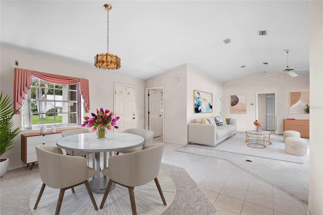 tiled dining area with lofted ceiling and ceiling fan with notable chandelier