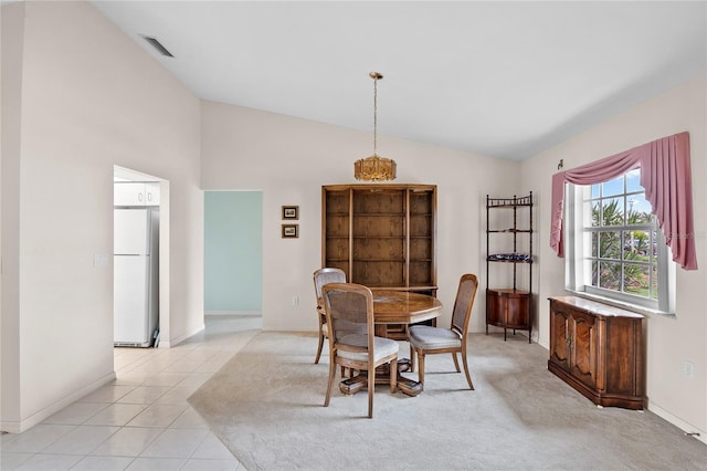 tiled dining space featuring vaulted ceiling